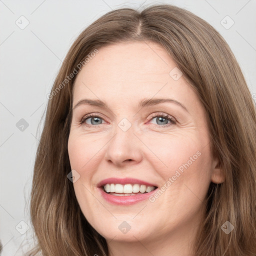 Joyful white adult female with long  brown hair and green eyes