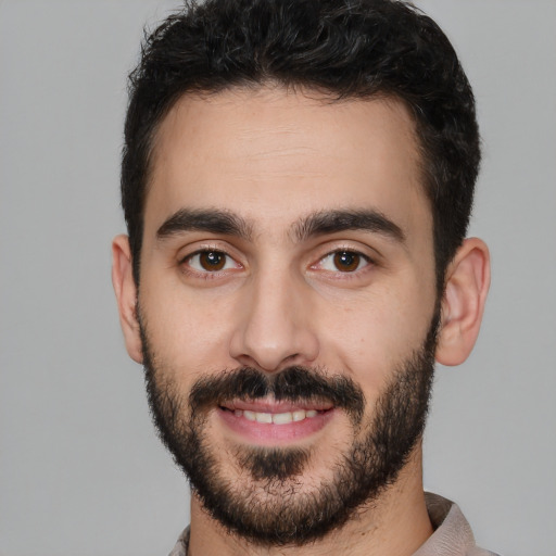 Joyful white young-adult male with short  black hair and brown eyes