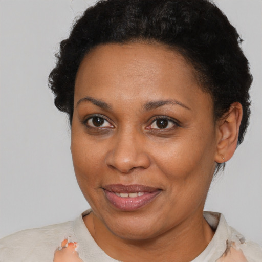 Joyful black adult female with short  brown hair and brown eyes