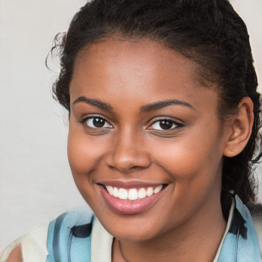 Joyful black young-adult female with long  brown hair and brown eyes