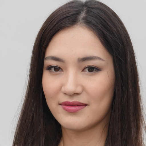 Joyful asian young-adult female with long  brown hair and brown eyes