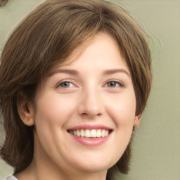 Joyful white young-adult female with medium  brown hair and green eyes