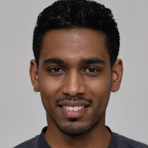 Joyful black young-adult male with short  black hair and brown eyes