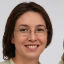 Joyful white adult female with medium  brown hair and green eyes