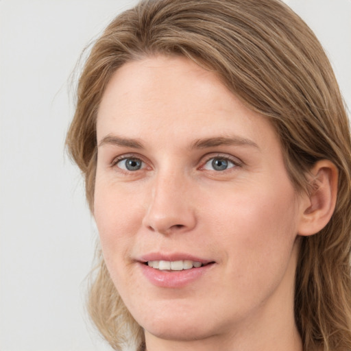 Joyful white young-adult female with long  brown hair and blue eyes