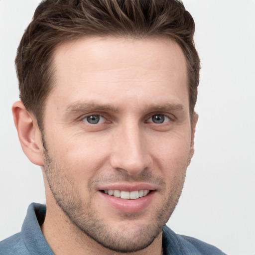 Joyful white young-adult male with short  brown hair and grey eyes