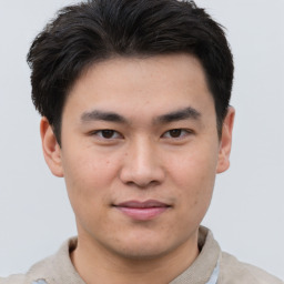 Joyful asian young-adult male with short  brown hair and brown eyes