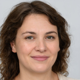 Joyful white adult female with medium  brown hair and green eyes