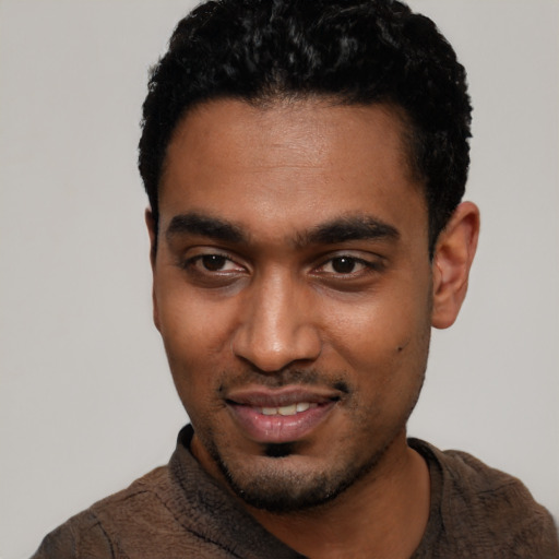 Joyful black young-adult male with short  black hair and brown eyes
