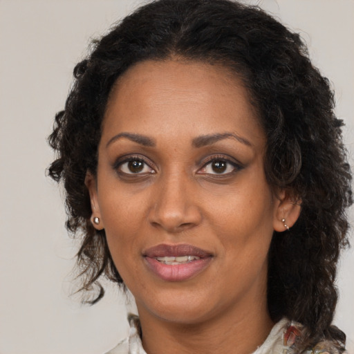 Joyful black adult female with medium  brown hair and brown eyes