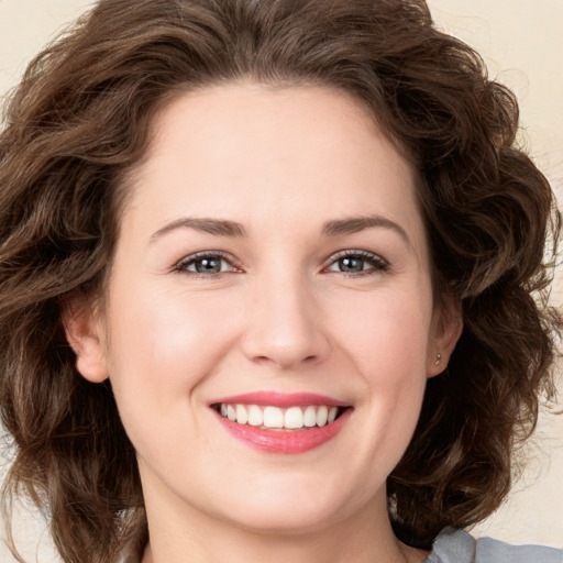 Joyful white young-adult female with long  brown hair and green eyes