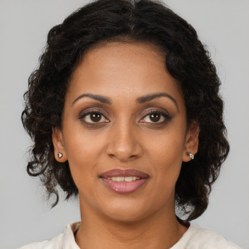 Joyful black young-adult female with medium  brown hair and brown eyes