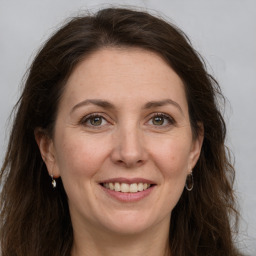 Joyful white adult female with long  brown hair and grey eyes