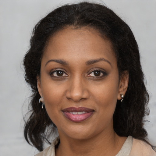 Joyful black young-adult female with long  brown hair and brown eyes