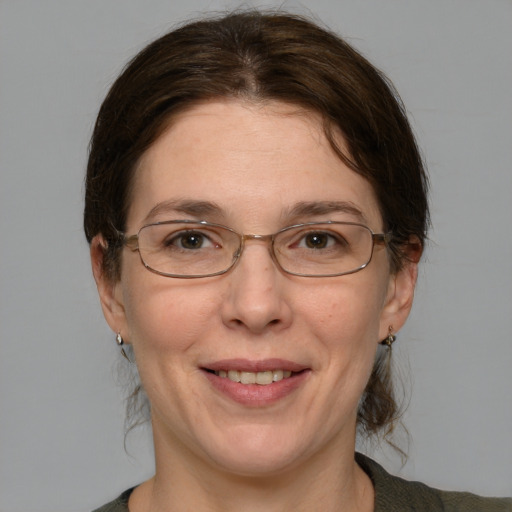 Joyful white adult female with medium  brown hair and blue eyes