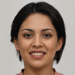 Joyful latino young-adult female with medium  brown hair and brown eyes