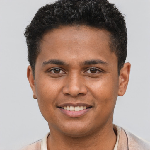 Joyful black young-adult male with short  brown hair and brown eyes