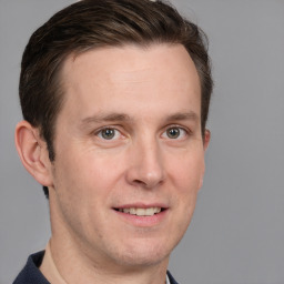 Joyful white adult male with short  brown hair and grey eyes