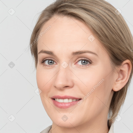 Joyful white young-adult female with medium  brown hair and grey eyes