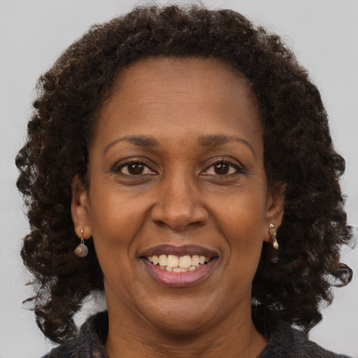 Joyful black adult female with medium  brown hair and brown eyes