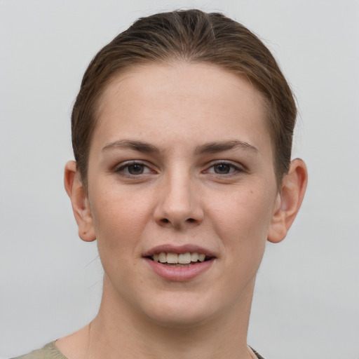 Joyful white young-adult female with short  brown hair and grey eyes