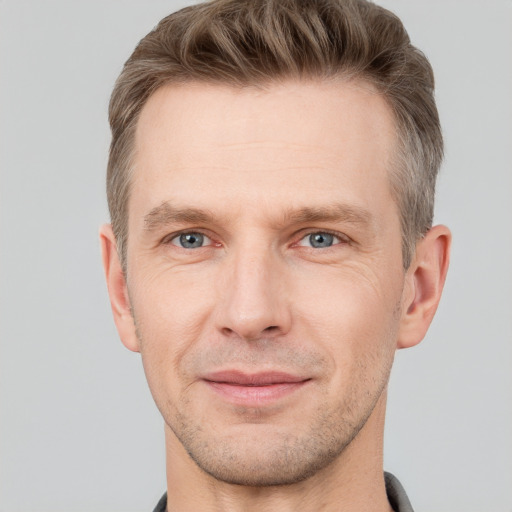 Joyful white adult male with short  brown hair and grey eyes