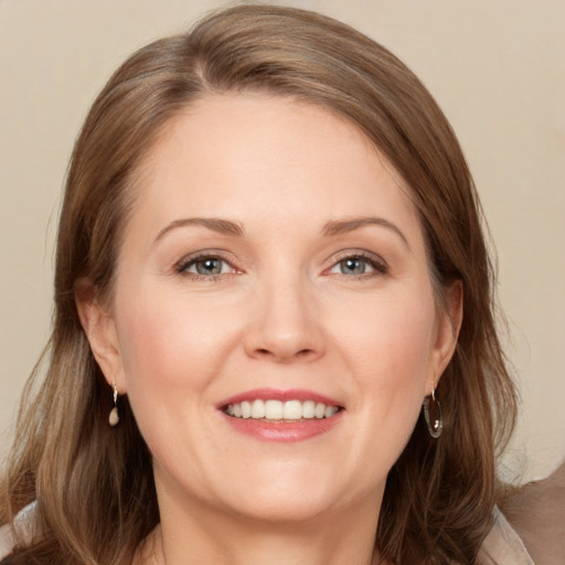 Joyful white adult female with medium  brown hair and grey eyes