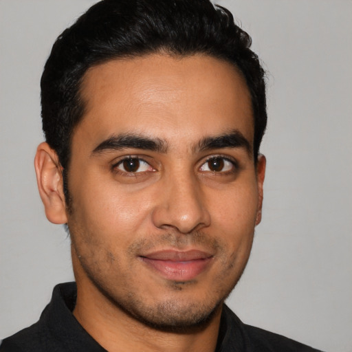 Joyful latino young-adult male with short  black hair and brown eyes