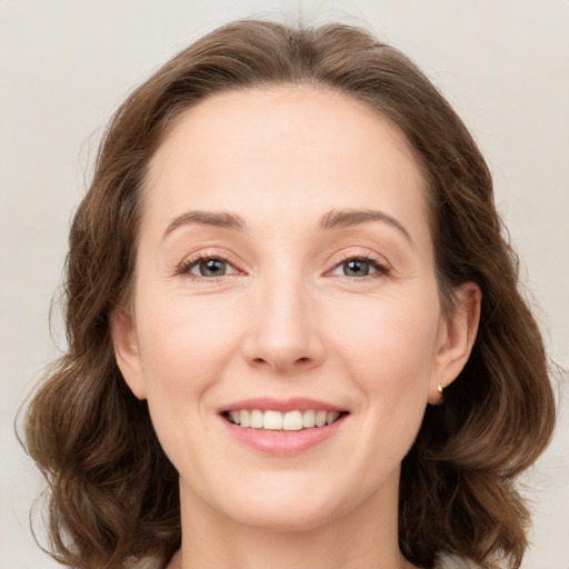 Joyful white young-adult female with medium  brown hair and green eyes