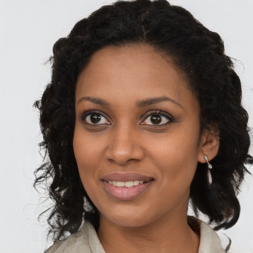 Joyful black young-adult female with long  brown hair and brown eyes