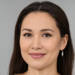 Joyful white young-adult female with long  brown hair and brown eyes