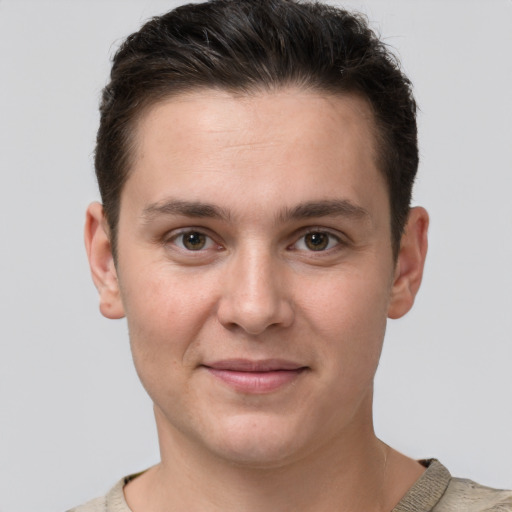 Joyful white young-adult male with short  brown hair and grey eyes