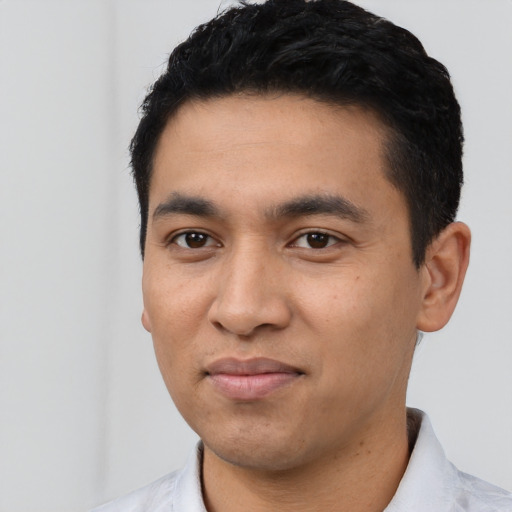 Joyful latino young-adult male with short  black hair and brown eyes
