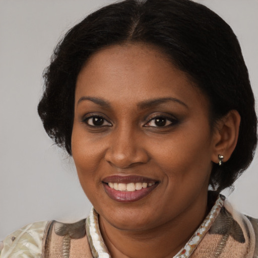 Joyful black young-adult female with short  brown hair and brown eyes