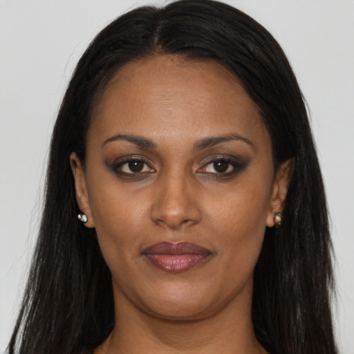 Joyful black young-adult female with long  brown hair and brown eyes