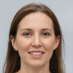 Joyful white young-adult female with long  brown hair and grey eyes