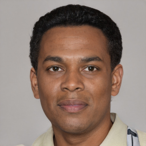 Joyful black young-adult male with short  black hair and brown eyes