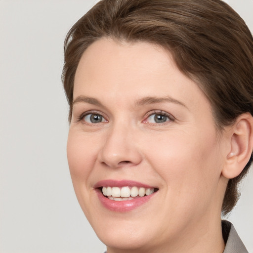 Joyful white adult female with medium  brown hair and grey eyes