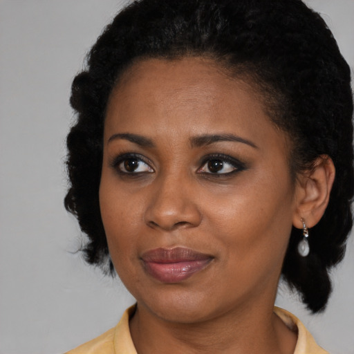Joyful black young-adult female with medium  black hair and brown eyes