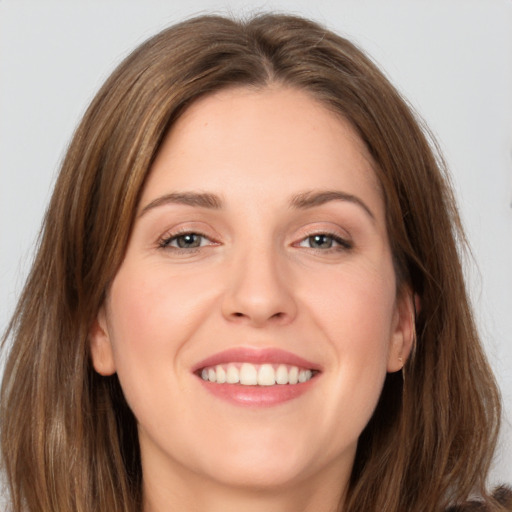 Joyful white young-adult female with long  brown hair and grey eyes