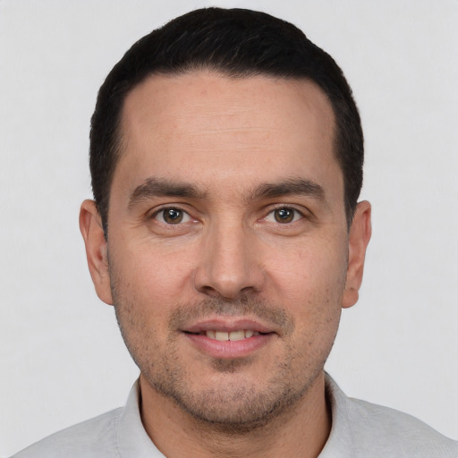 Joyful white young-adult male with short  black hair and brown eyes