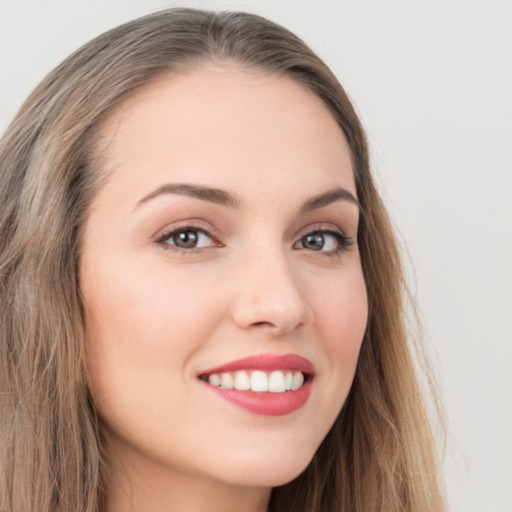 Joyful white young-adult female with long  brown hair and green eyes