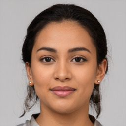 Joyful latino young-adult female with medium  brown hair and brown eyes