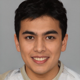 Joyful latino young-adult male with short  brown hair and brown eyes