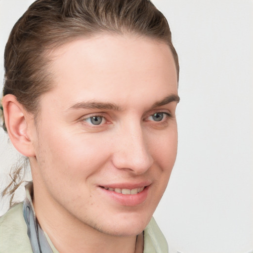 Joyful white young-adult male with short  brown hair and blue eyes