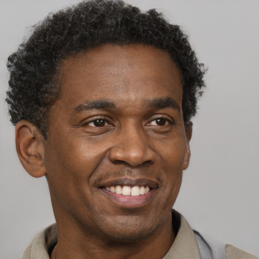 Joyful black adult male with short  brown hair and brown eyes