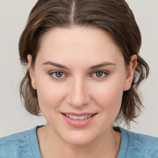 Joyful white young-adult female with medium  brown hair and blue eyes