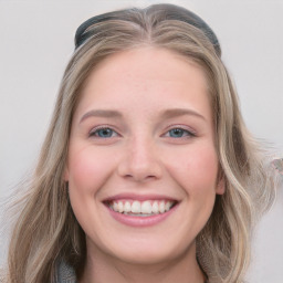 Joyful white young-adult female with long  brown hair and blue eyes