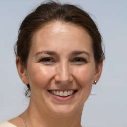 Joyful white adult female with medium  brown hair and brown eyes