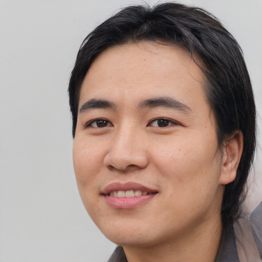 Joyful asian young-adult male with medium  black hair and brown eyes